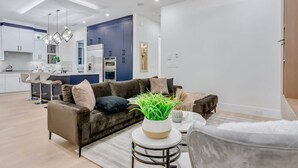 Un salon moderne avec un canapé marron foncé, une table basse ronde et une plante en pot.