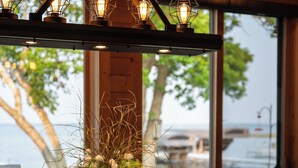 A wooden ceiling with exposed beams and a hanging light fixture with multiple bulbs. - Lake Bemidji retreat- modern, cozy cabin spacious enough for family and friends. (Bemidji)
