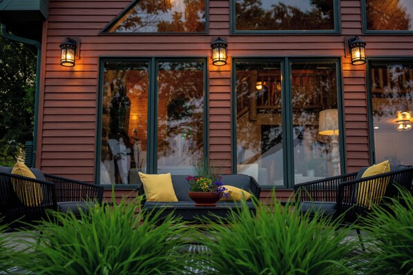 Een modern huis met grote ramen, terras en decoratieve verlichting.