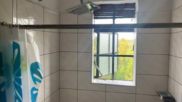 Habitación doble Deluxe, vista al jardín | Baño | Regadera, pantuflas, toallas, jabón