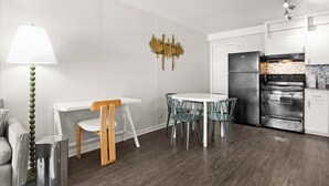 A modern kitchen with white cabinetry, a black refrigerator, and a tiled backsplash. - Cozy Studio Walk to UT & Moody 7 Min to ACL (Austin)