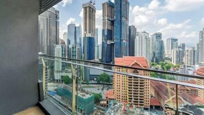 Vista de la ciudad desde un balcón, con edificios modernos y alto y bajos de construcción a la vista.
