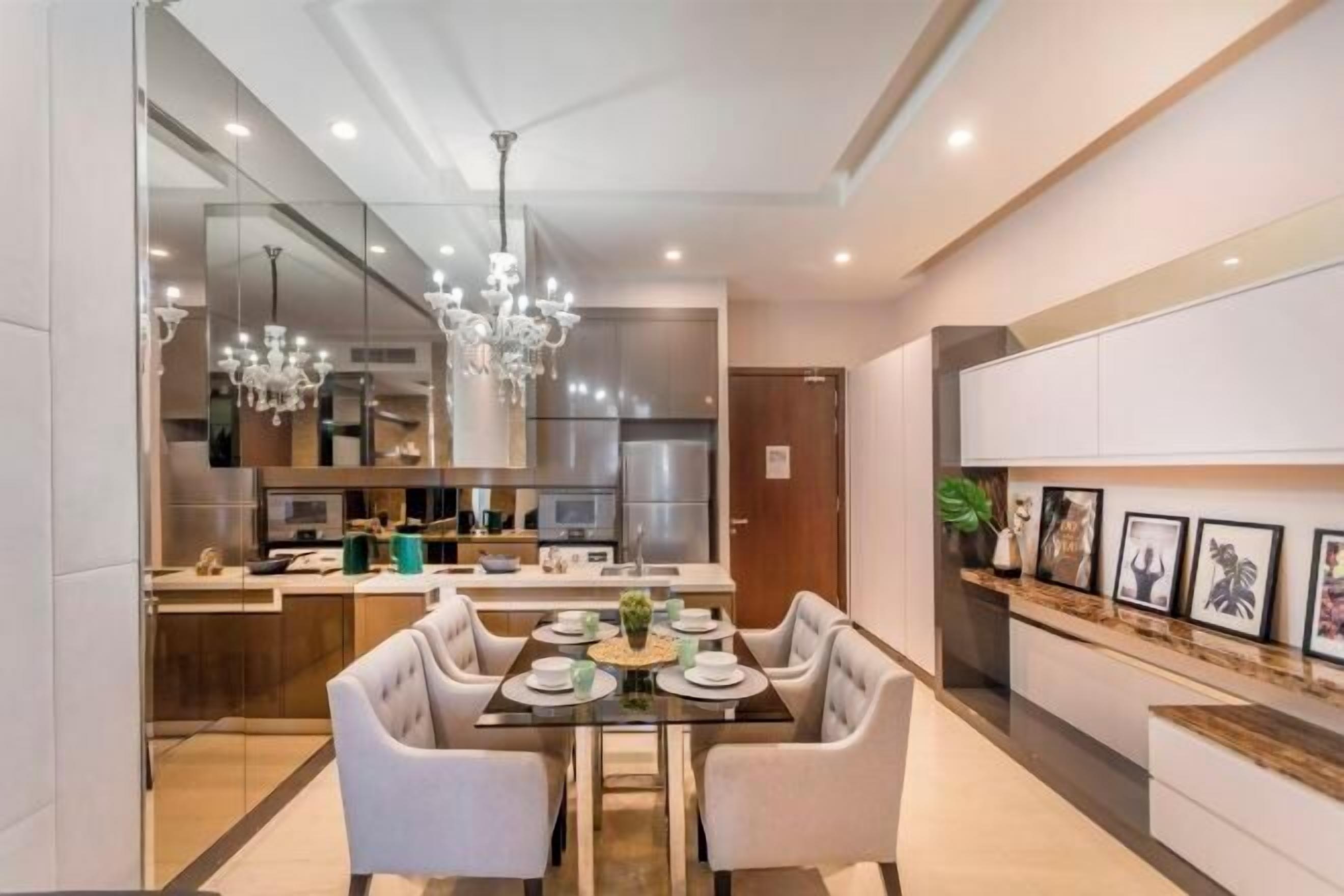 A modern dining area with a glass table, white upholstered chairs, and a chandelier. - Dorsett Bukit Bintang 5min to Pavilion KL (Kuala Lumpur)