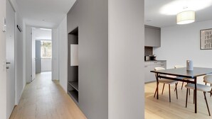 Una cuina moderna amb zona de menjador, terres de fusta i vistes a l'exterior.