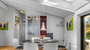 A modern dining area with a round table, four chairs, a pendant light, and a view through a glass door. - "Sigbrit" - 100m from the sea by Interhome (Tranekær)