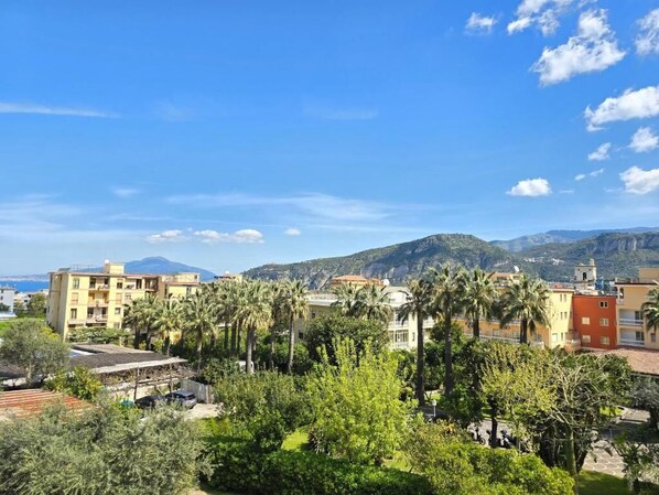 A residential area with buildings, palm trees, and a mountain in the background. - Casa Evelina (Sant'Agnello)