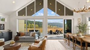 Ein geräumiges Wohnzimmer mit großem Fenster, Essbereich und gemütlichem Sitzbereich.