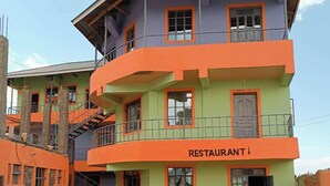 Un immeuble à plusieurs étages, avec une enseigne indiquant qu’il y a un restaurant au rez-de-chaussée.