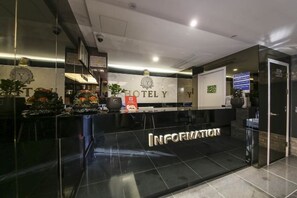 A hotel reception area with a reception desk, a sign reading 'HOTEL Y', and a digital screen displaying information. - Eunpyeong Y Hotel (Seoul)