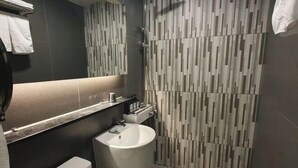Une salle de bain moderne équipée de toilettes, d’un lavabo et d’une zone douche.