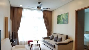 A modern living room with a sofa, a coffee table, a ceiling fan, and a painting on the wall. - Soho Suites @ KLCC by Luxury Suites Asia (Kuala Lumpur)