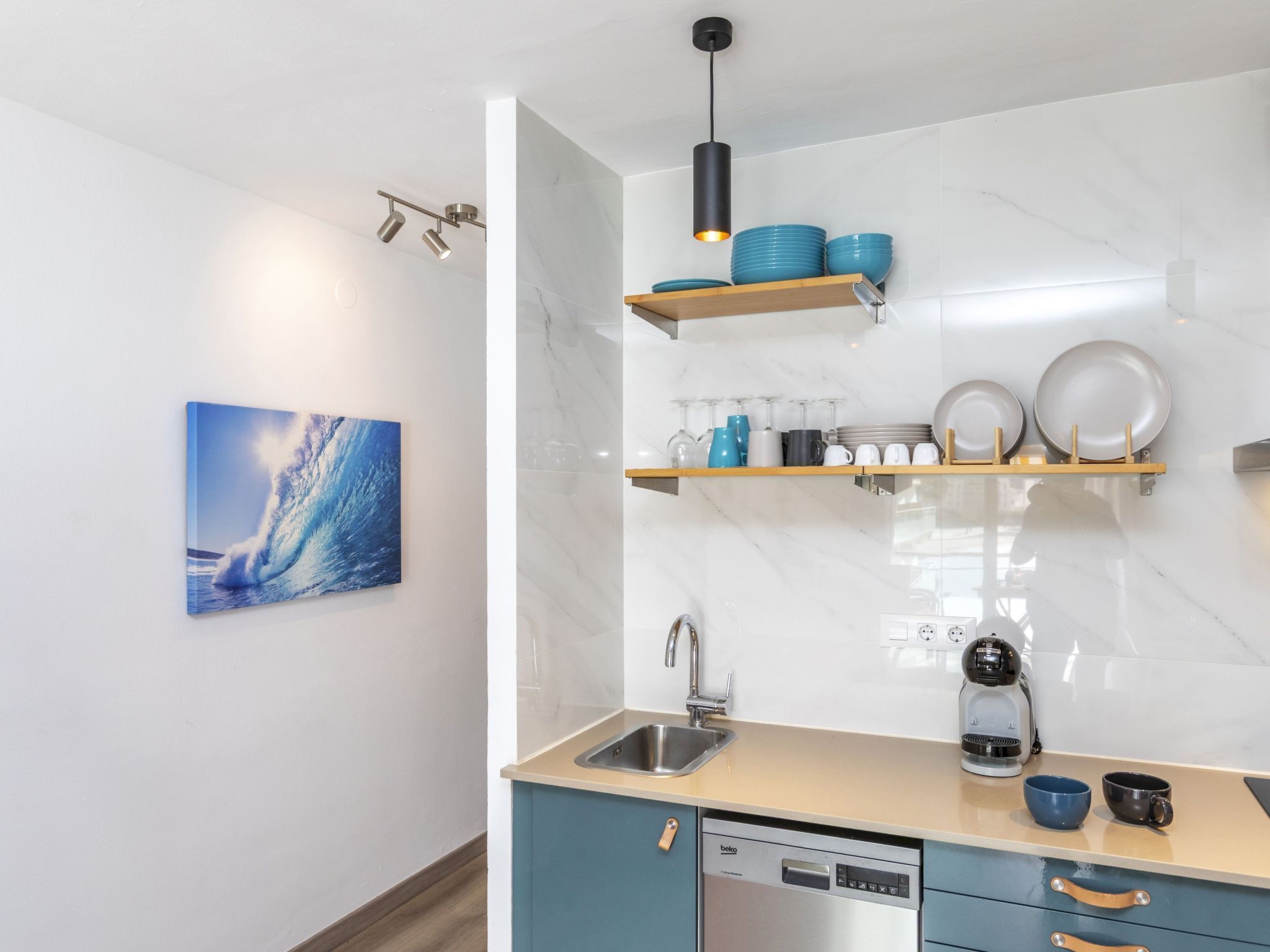A modern kitchen with a dishwasher, a coffee machine, and a sink.