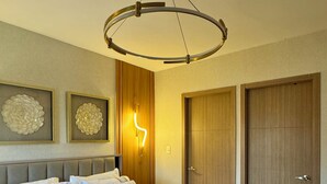 Een moderne slaapkamer met een groot bed, een ronde plafondlamp en twee houten deuren.