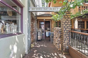 A narrow alleyway leading to a hotel entrance with a sign above.