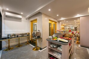 Eine moderne Küche mit Marmorboden, einer Kaffeestation und einem Buffetbereich.