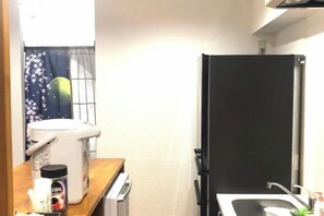 A compact kitchen with a microwave, a coffee maker, and a sink. - Guest House Siesta (Tokyo)
