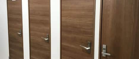 A row of wooden doors with signs indicating they are toilet rooms.