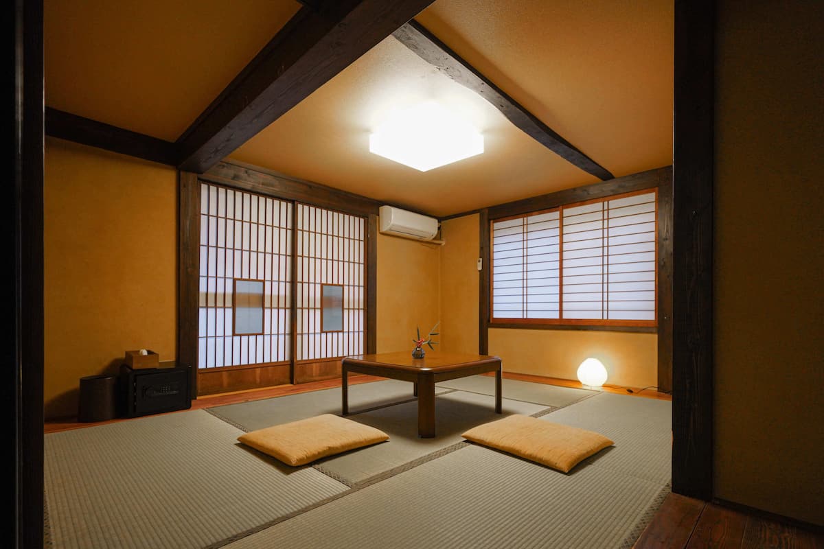 A traditional Japanese room with tatami flooring, a low table, and shoji screens.