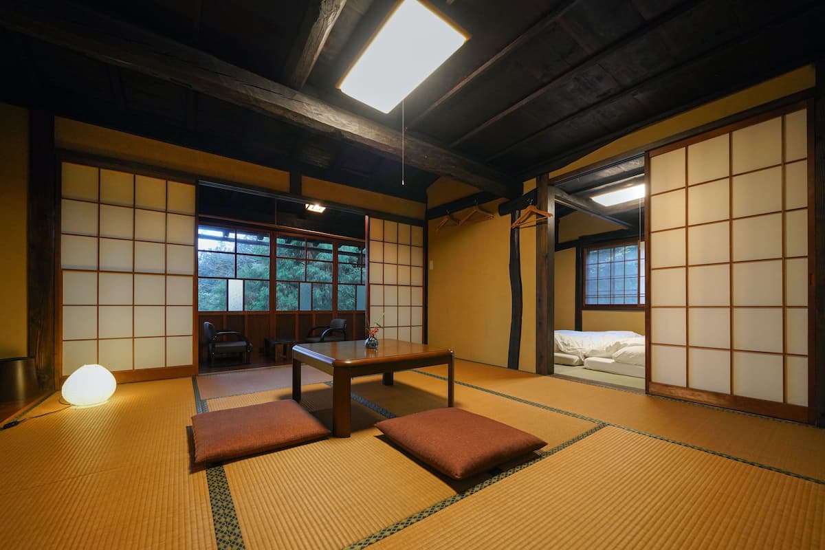 A traditional Japanese room with tatami flooring, a low table, and sliding doors.