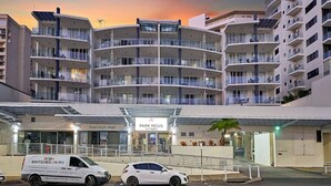 A multi-story hotel with a curved facade, a covered entrance, and a sign for 'Park Regis City Quays'. - Luxurious City Centre Apartment - Space & Style (Cairns City)