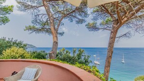 Eine Terrasse mit Korbmöbeln und Blick auf das Meer.