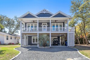 Une maison à deux étages avec un balcon, un porche et un garage.
