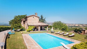 A villa with a swimming pool, outdoor seating, and a view of the countryside. - Italian Experience- Villa Incanto (Potenza Picena)
