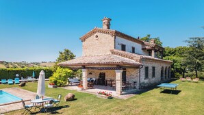 A two-story house with a patio, outdoor seating, and a swimming pool. - Italian Experience- Villa Incanto (Potenza Picena)