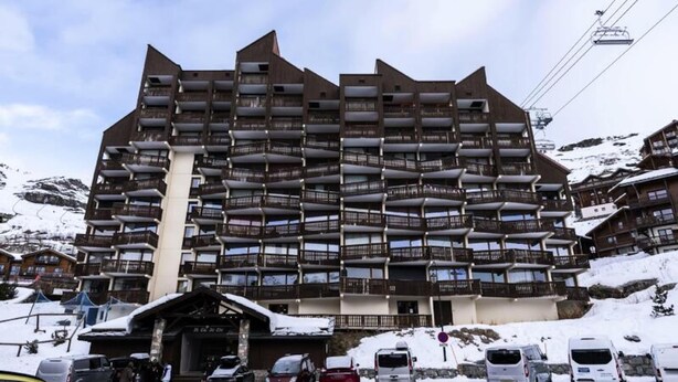 A multi-story hotel with balconies, a ski lift in the background, and snow-covered surroundings. - Holiday Home in Val Thorens Ski Area (Les Belleville)