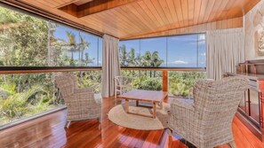 A room with a large window, a wooden ceiling, and a table with chairs. - Elysian (Terranora)