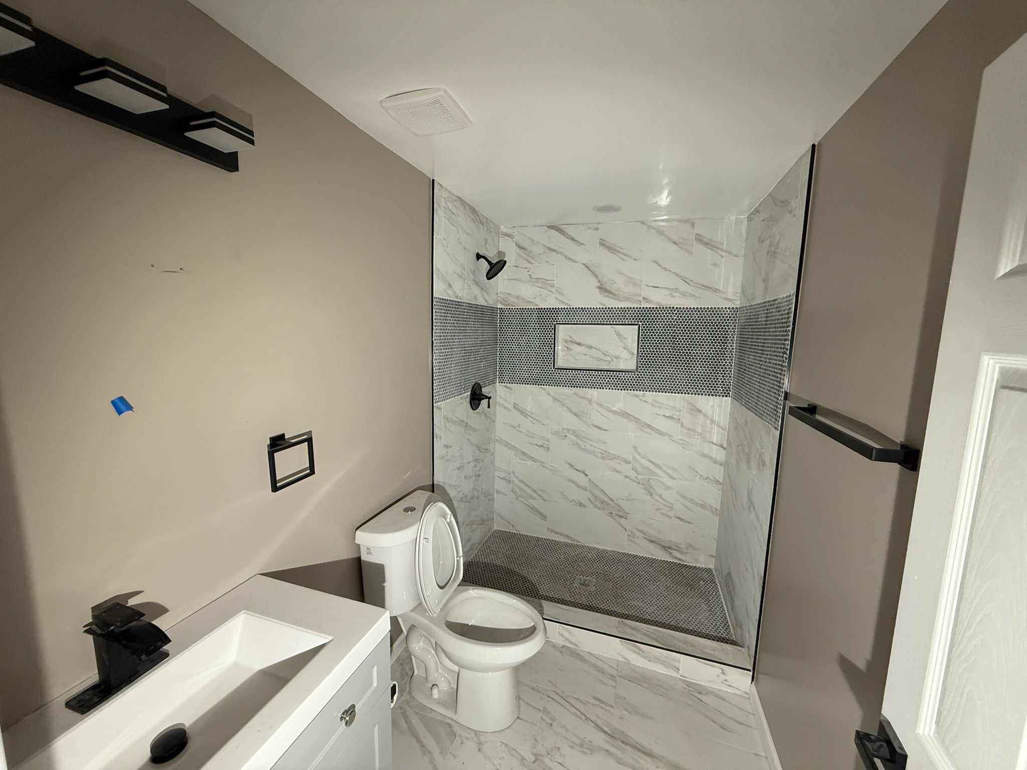 Un bagno piccolo con toilette, lavandino e zona doccia.