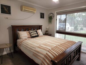 Tabla de planchar con plancha, internet y ropa de cama