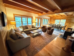 A cozy living room with a sofa, chairs, a coffee table, and a fireplace.