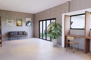 Een moderne woonkamer met een bank, een bureau en een grote potplant.