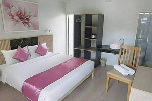 A hotel room with a bed, a desk with a computer, a chair, a sink, and a wardrobe. - Ko Lanta Hotels and Working Space (Koh Lanta)