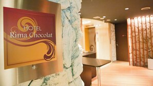 A hotel reception area with a sign for 'HOTEL Rima Chocolat'. - Hotel Rima chocolat (Sapporo)