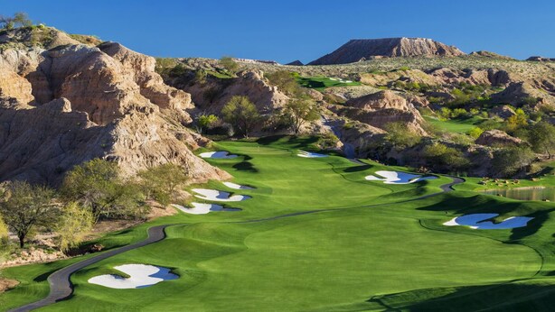 Un parcours de golf avec des bunkers, des obstacles d’eau et un pont.