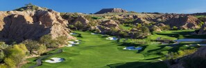 A golf course with bunkers, water hazards, and a bridge.