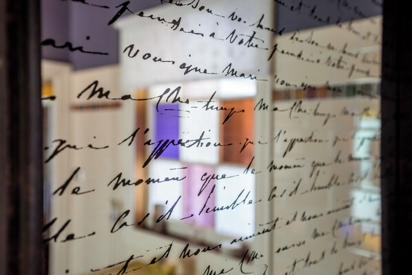 A close-up of handwritten notes on a glass surface with blurred background elements. - Chinoiserie (Katoomba)
