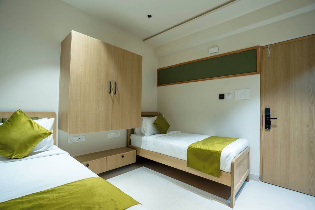 Et moderne hotelværelse med køjeseng, garderobeskab, skrivebord og et lille siddeområde.