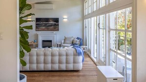 Un dormitorio con una cama grande, una chimenea y vistas amplias a través de grandes ventanales.