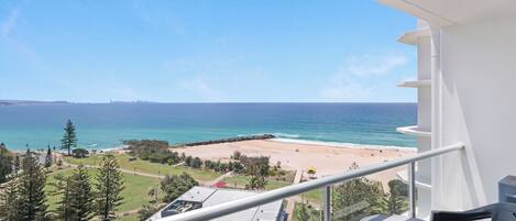 A balcony with a view of a beach and ocean.