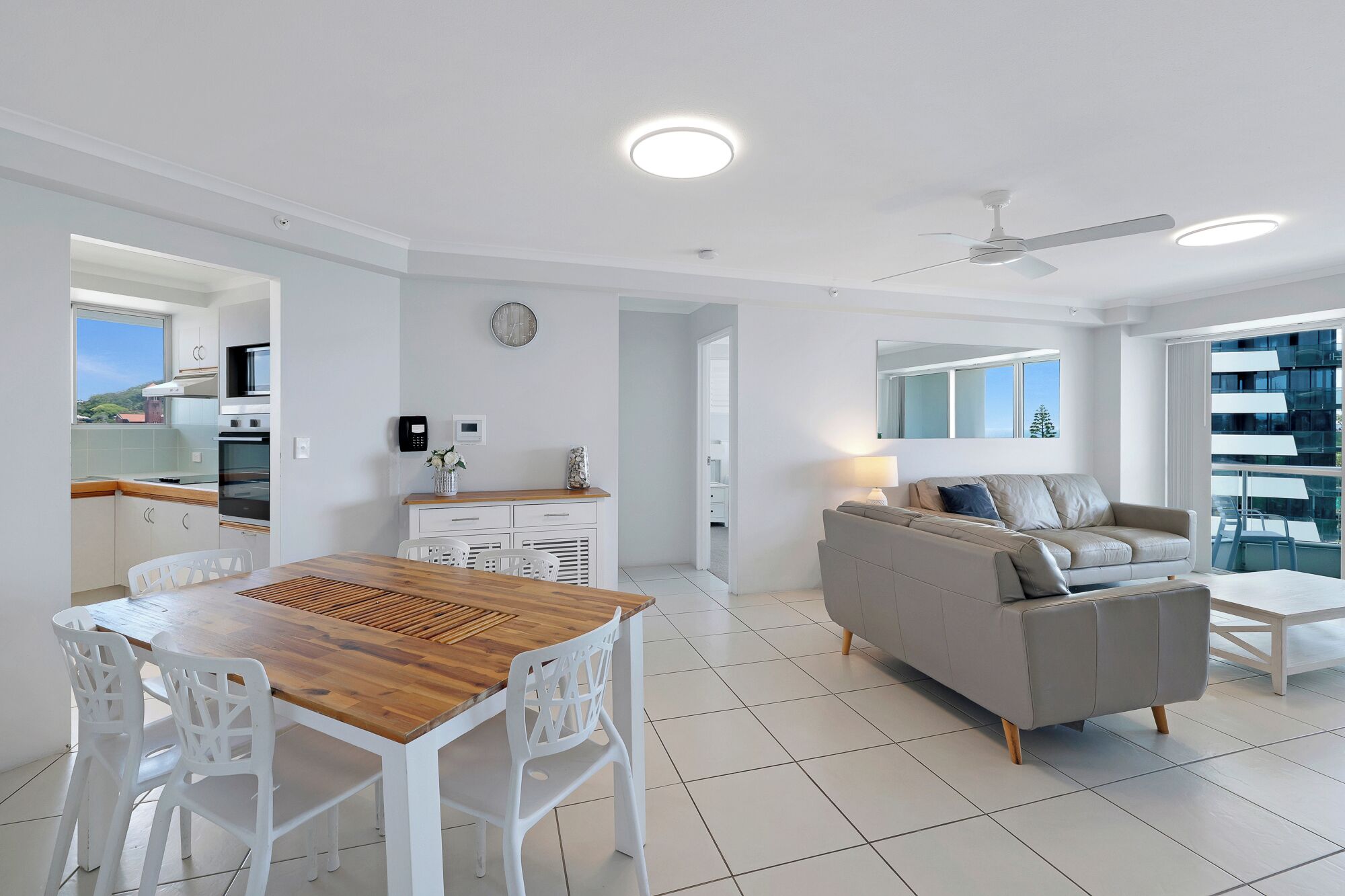 Um apartamento moderno com área de refeições, cozinha, sala de estar e varanda.