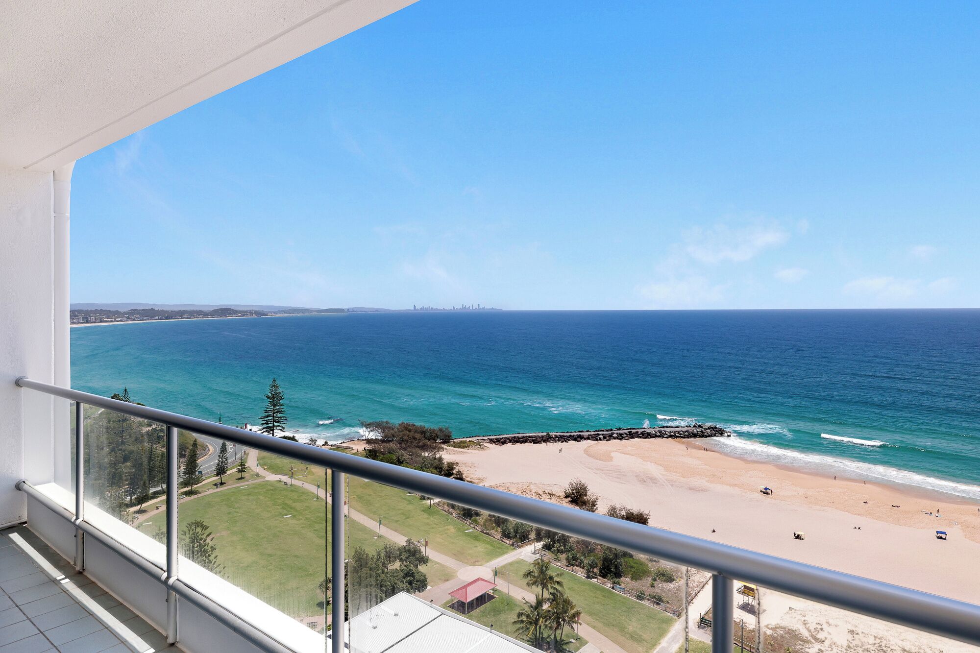 A balcony with a clear view of a beach and ocean.