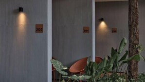 Un intérieur moderne avec des murs à rayures verticales, des panneaux numérotés et un grand tronc d’arbre.