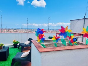 Terraço no terraço com vista da cidade, área de estar externa e pinwheels coloridos.