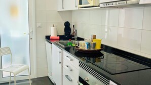 A modern kitchen with white cabinets, a black countertop, and a stainless steel range hood. - Atico Duplex 4 Habitaciones 3 Terrazas Vista 360° (Barcelona)