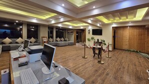 A modern hotel lobby with a reception desk, seating area, and a large wooden door. - Shimla Golf Resorts (Shimla)