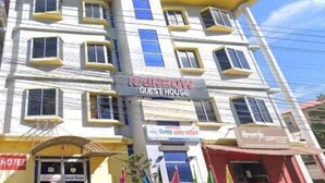 A multi-story building with a sign indicating it is a guest house.