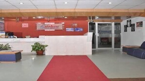 A reception area with a red carpet, a reception desk, blue seating, and a sign that reads "Rainbow."